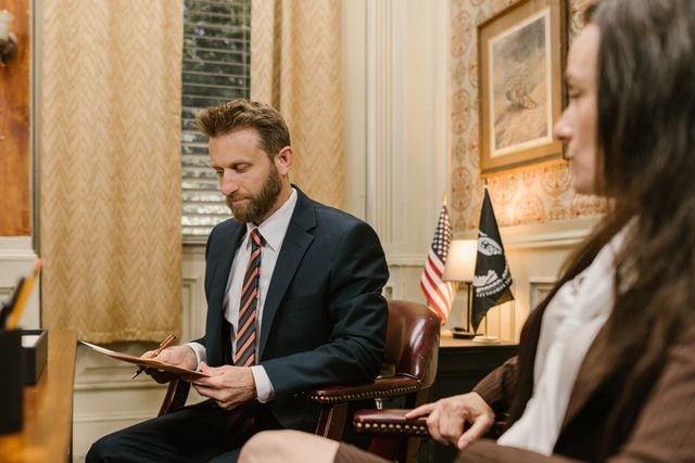 Photo by RDNE Stock project: https://www.pexels.com/photo/a-man-in-a-suit-looking-at-a-document-while-sitting-in-an-armchair-7841474/